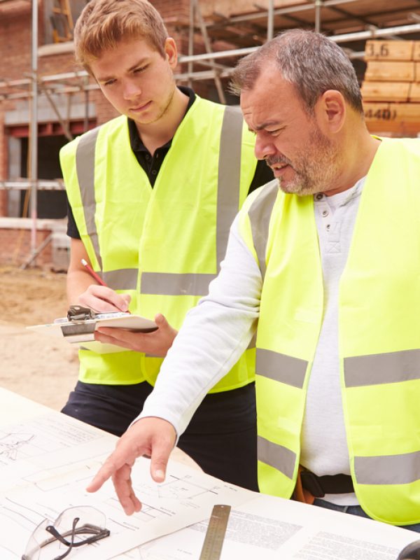 Builder,On,Building,Site,Discussing,Work,With,Apprentice
